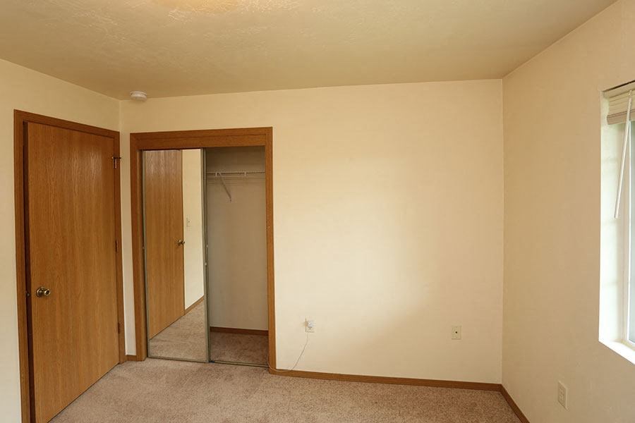 an empty room with a closet and a mirror