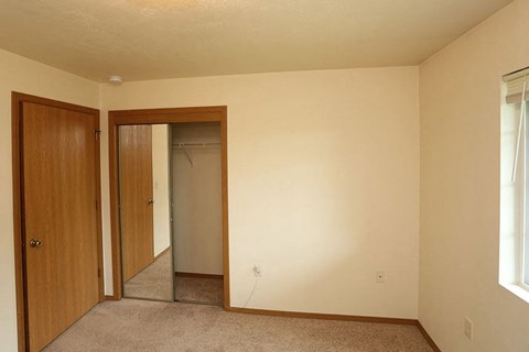 an empty room with a closet and a mirror