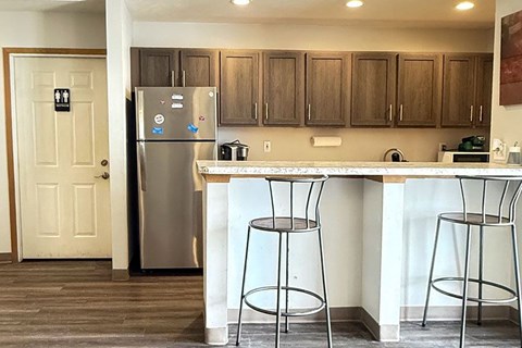 A kitchen with a white fridge and a white counter top.