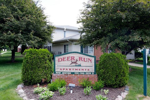 a deer run apartments sign in front of a house