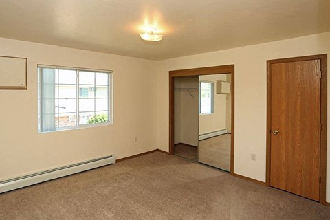 an empty living room with a door and a mirror