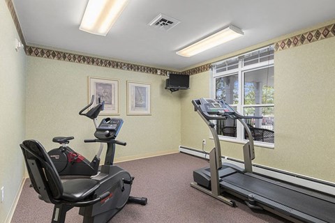 a gym with exercise equipment and a large window