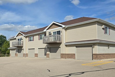 A row of houses with garages and balconies.