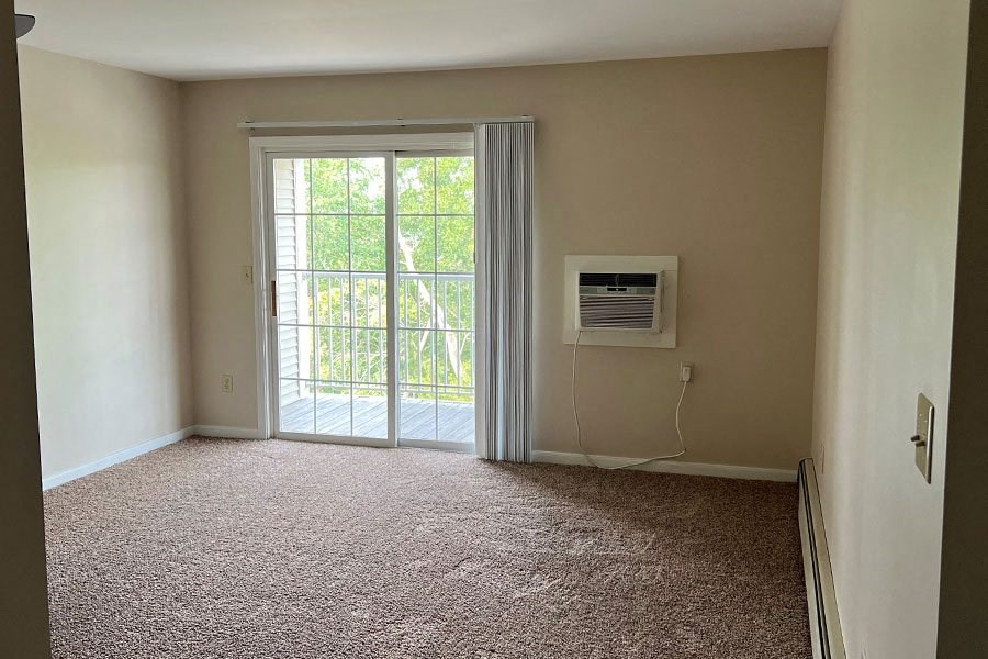 an empty room with a window and a air conditioner