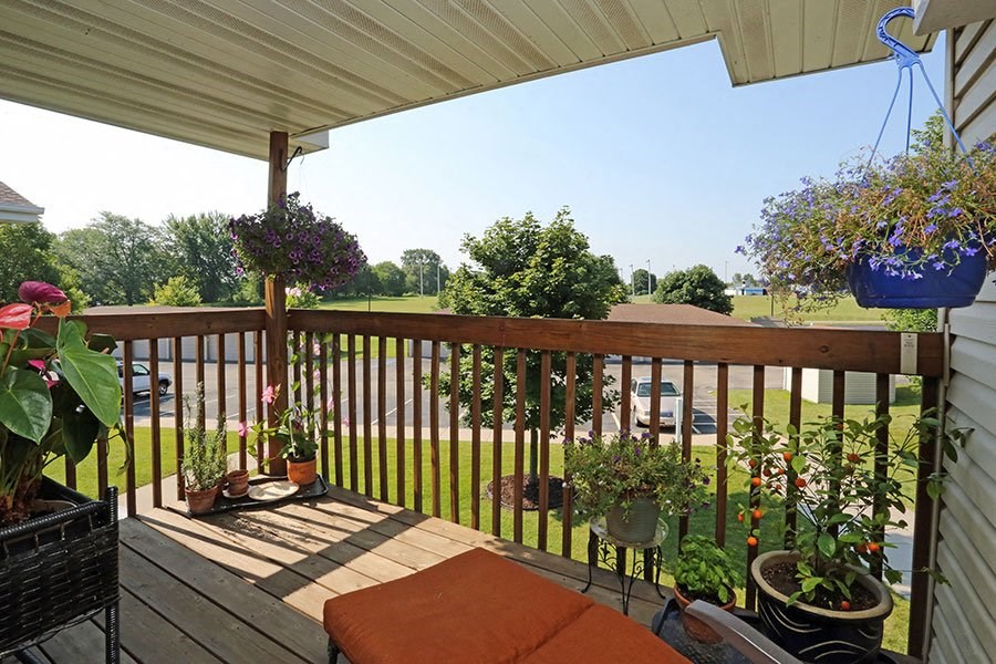 a porch with potted plants and a view of a field