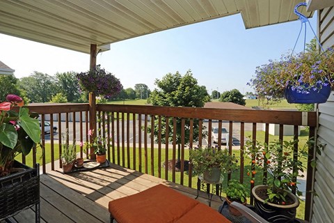 a porch with potted plants and a view of a field