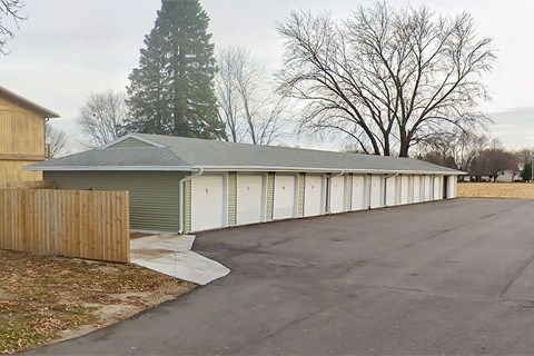 a garage with white doors and a parking lot