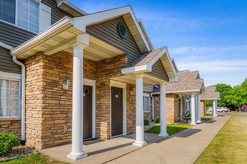 A row of houses with brown doors and white columns.