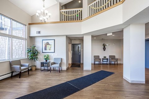 A spacious living room with a staircase and a large window.