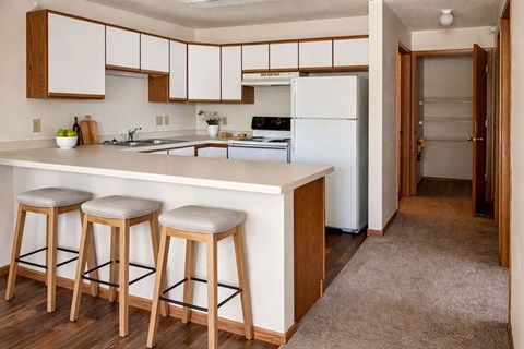 A kitchen with white appliances and wooden cabinets.