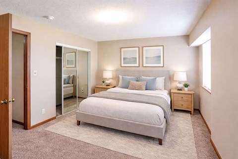 A bedroom with a bed, nightstands, and a mirror.