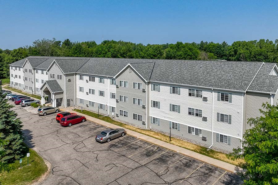 an aerial view of an apartment building with cars parked