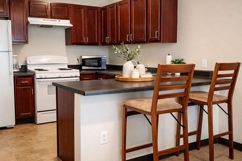 A kitchen with wooden cabinets and a white stove.