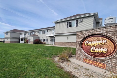 A sign for Copper Cove is in front of a building.