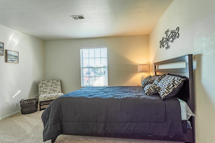 a bedroom with a bed and a chair