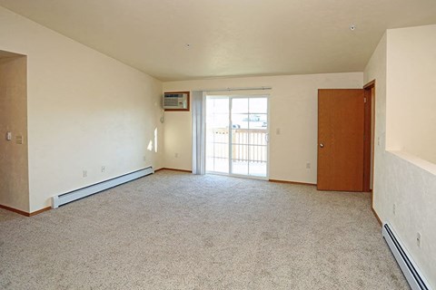 an empty living room with a door to a balcony