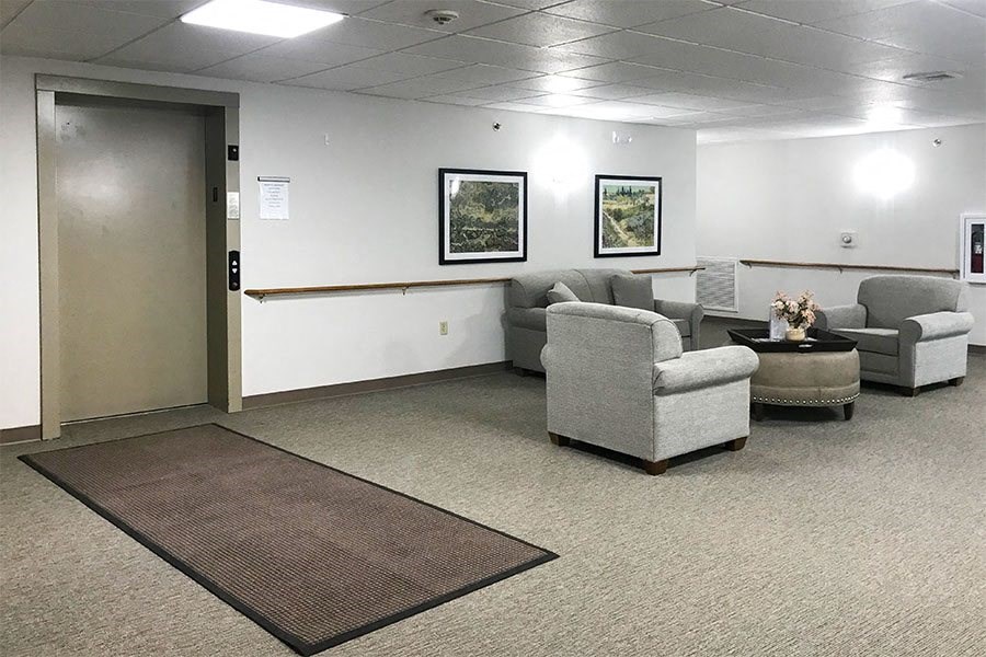 a living room with couches and chairs and a door