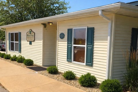 A small building with a sign on the front door.