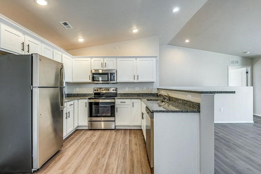 a kitchen with white cabinets and stainless steel appliances
