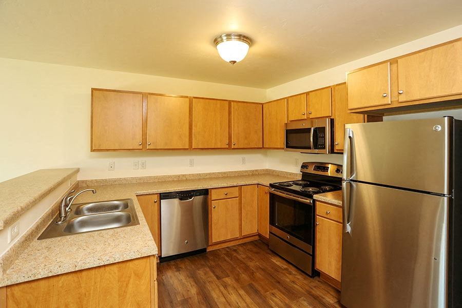 a kitchen with stainless steel appliances and wooden cabinets