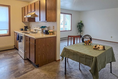 A kitchen with a table and chairs in the living room.