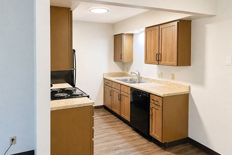 A kitchen with wooden cabinets and a black stove top.