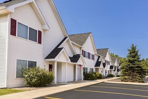 a row of white houses with red shutters