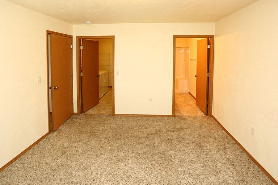 a empty room with two doors and a carpeted floor