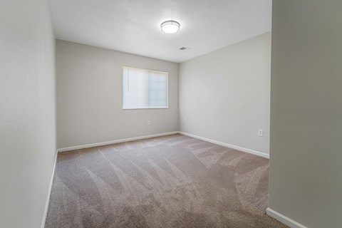 A room with a carpeted floor and a window.