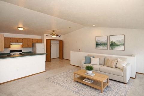 A living room with a couch, a coffee table, and two pictures on the wall.