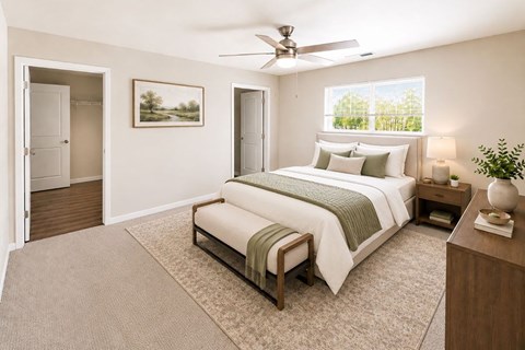 A bedroom with a large bed and a ceiling fan.