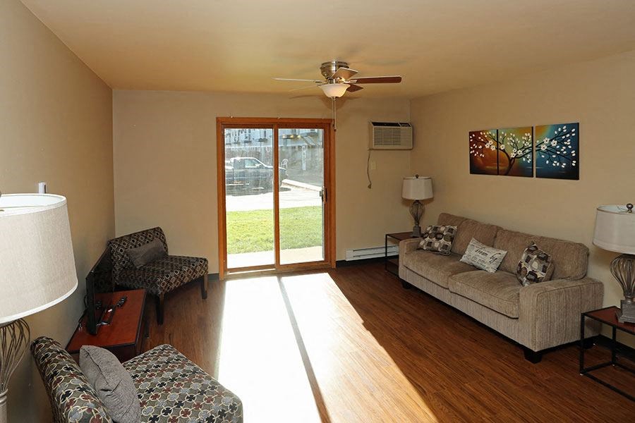 A living room with a couch, chair, and a ceiling fan.