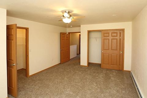 a empty room with a ceiling fan and a closet
