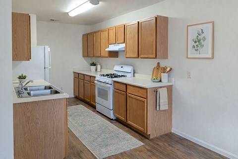 A kitchen with wooden cabinets and a white stove top oven.