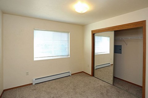 an empty room with a mirror and a closet