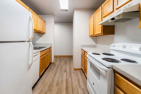 A kitchen with white appliances and wooden cabinets.