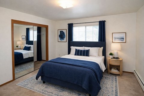 A bedroom with a large bed and a mirror on the wall.