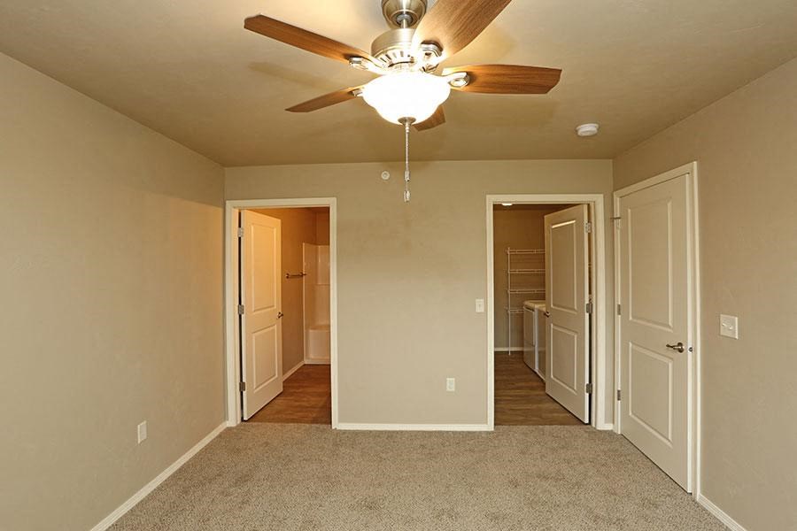 a empty room with a ceiling fan and a closet
