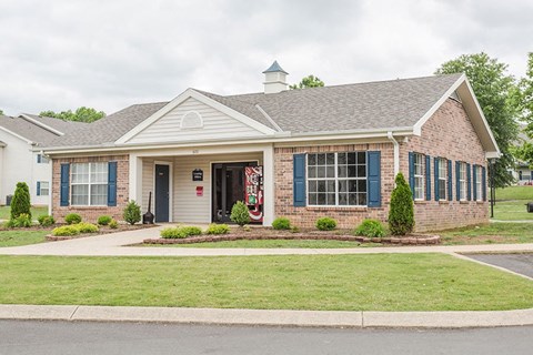 a brick house with blue shutters and a lawn