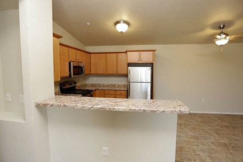 an empty kitchen with a granite counter top