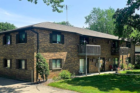 A brick building with a green lawn in front.