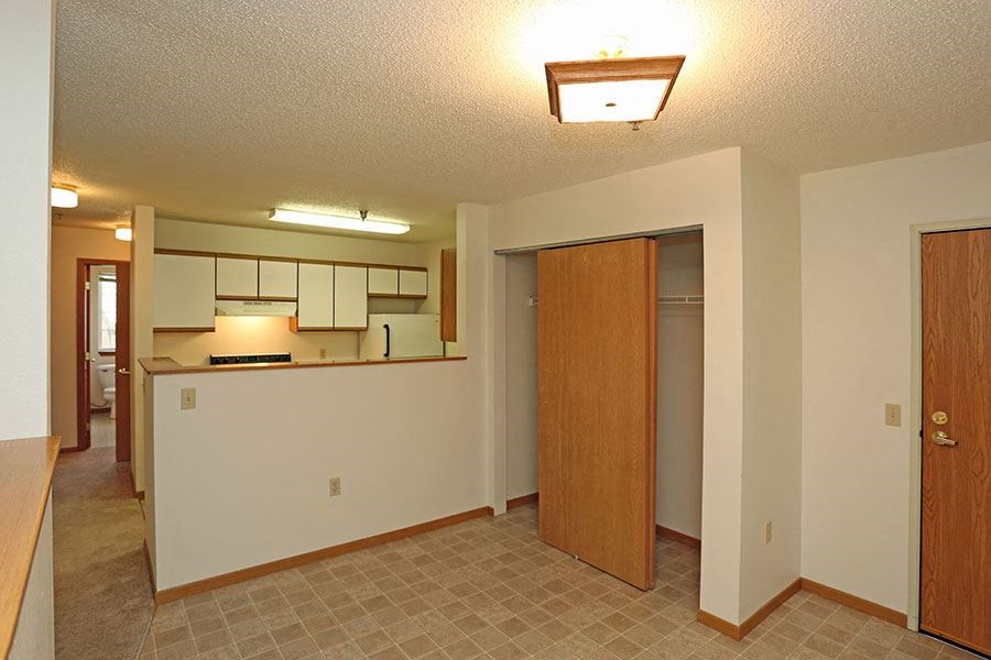 an empty room with a kitchen and a door