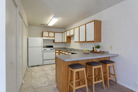 A kitchen with white appliances and wooden cabinets.