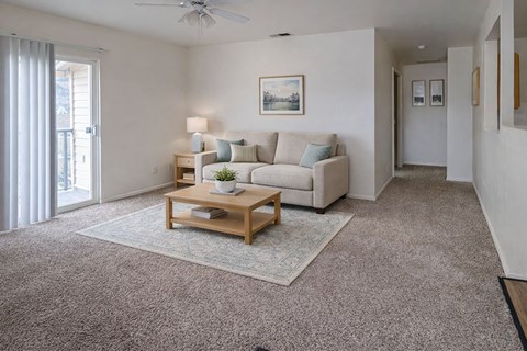 A living room with a couch, a coffee table, and a painting on the wall.