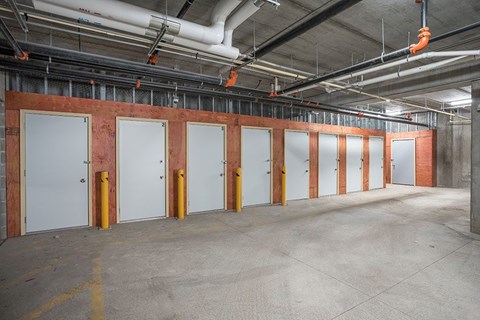A long row of white doors are lined up in a building.