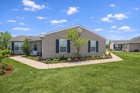 A house with a well-maintained lawn and a clear blue sky.