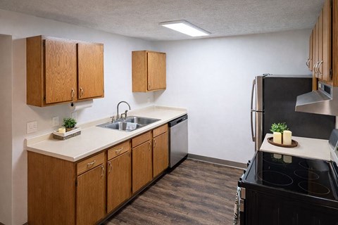 A kitchen with wooden cabinets and a black stove top.