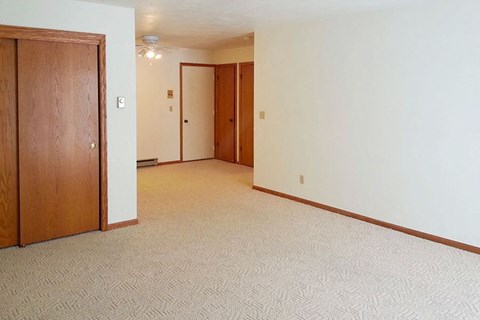 an empty living room with a door to a bedroom