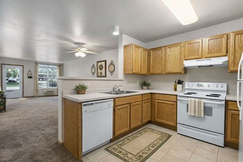 A kitchen with a white dishwasher and white stove.