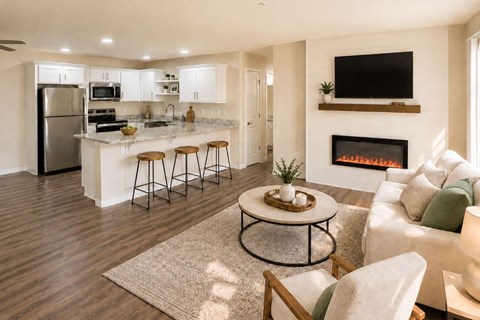 A modern kitchen with a bar and a fireplace in the living room.